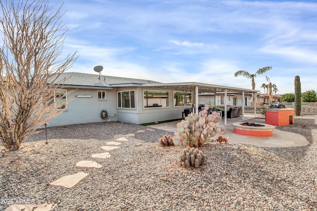 back of property featuring a patio and a fire pit