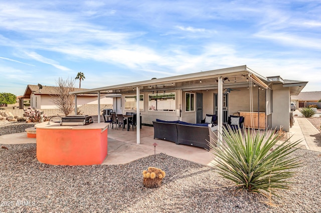 back of property featuring ceiling fan, a patio area, and an outdoor living space