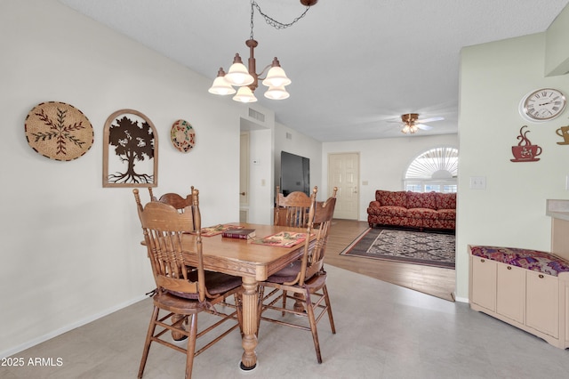 dining space with ceiling fan with notable chandelier