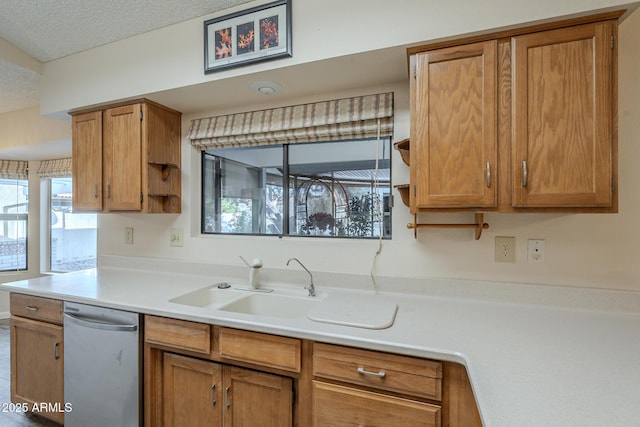 kitchen featuring brown cabinets, open shelves, light countertops, stainless steel dishwasher, and a sink