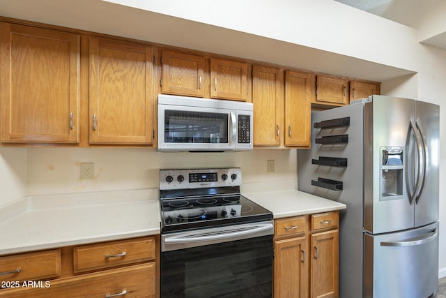 kitchen with light countertops, appliances with stainless steel finishes, and brown cabinets