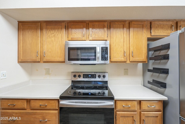 kitchen featuring brown cabinets, stainless steel appliances, and light countertops