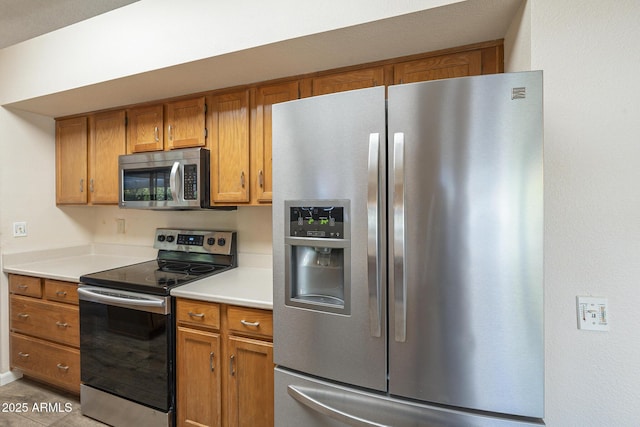 kitchen with stainless steel appliances, light countertops, and brown cabinets