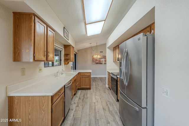 kitchen featuring lofted ceiling, stainless steel appliances, light countertops, light wood-type flooring, and brown cabinetry