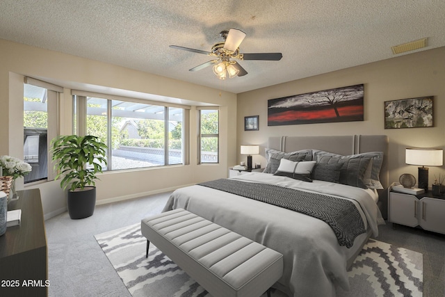 carpeted bedroom featuring baseboards, visible vents, ceiling fan, and a textured ceiling