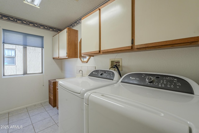 laundry room with cabinet space, washing machine and dryer, baseboards, and light tile patterned flooring