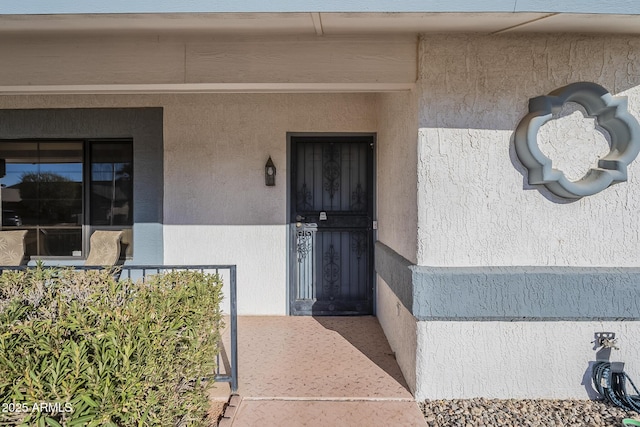 entrance to property featuring stucco siding