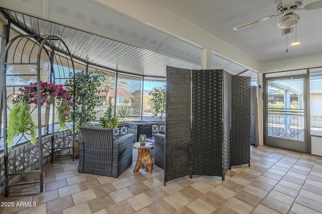 unfurnished sunroom featuring a ceiling fan