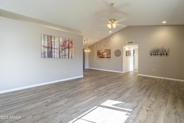 unfurnished living room featuring ceiling fan with notable chandelier, wood finished floors, visible vents, and baseboards