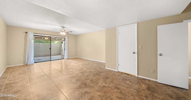 tiled spare room with a textured ceiling and ceiling fan