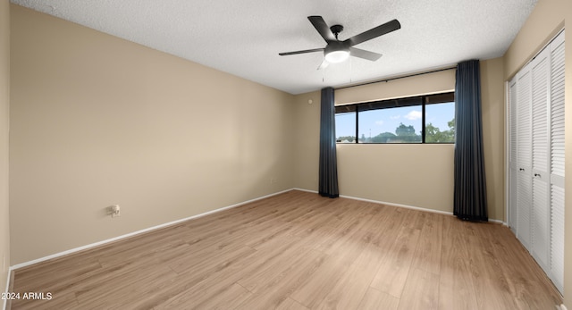 empty room featuring light hardwood / wood-style flooring, a textured ceiling, and ceiling fan