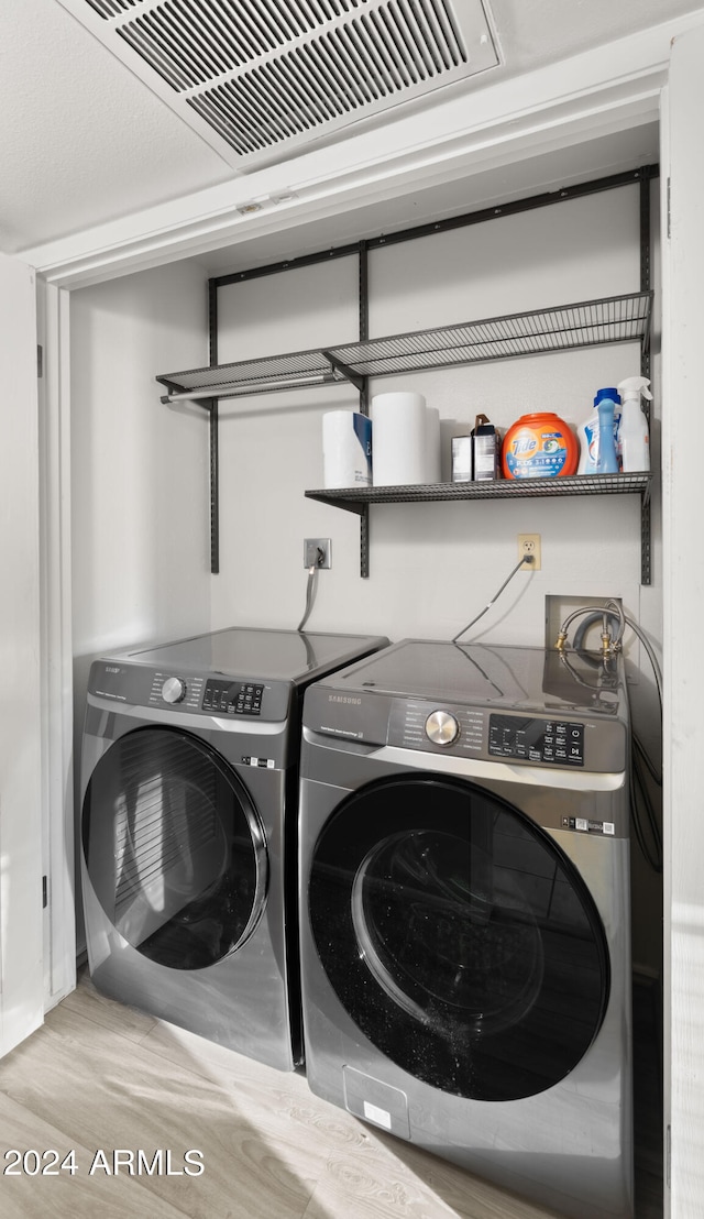 laundry room featuring washer and clothes dryer and hardwood / wood-style flooring