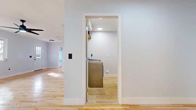 interior space featuring washer / clothes dryer, light hardwood / wood-style floors, and ceiling fan