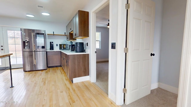 kitchen with stainless steel refrigerator with ice dispenser, ceiling fan, and light hardwood / wood-style flooring