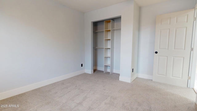 unfurnished bedroom featuring a closet and light carpet