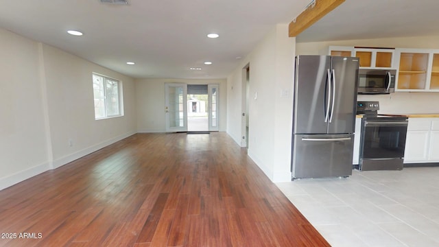 kitchen featuring appliances with stainless steel finishes, white cabinets, and light hardwood / wood-style floors