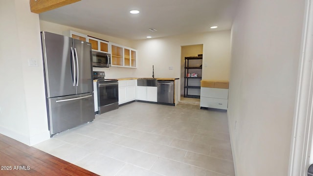 kitchen with stainless steel appliances, sink, and white cabinets