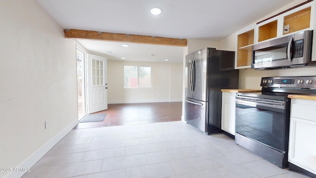 kitchen with stainless steel appliances, beam ceiling, and white cabinets