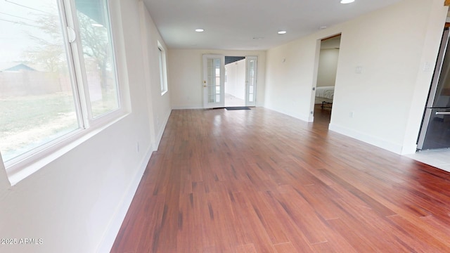 empty room with hardwood / wood-style floors and french doors