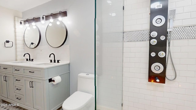 bathroom featuring vanity, a tile shower, and toilet