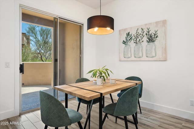 dining area featuring light wood finished floors and baseboards