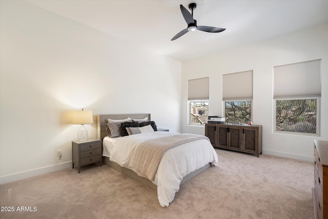 bedroom with light carpet, ceiling fan, and baseboards