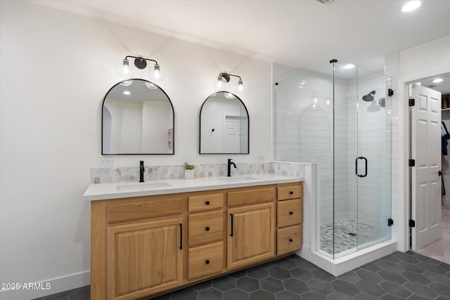 bathroom featuring a shower stall, tile patterned flooring, double vanity, and a sink