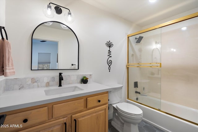 bathroom featuring bath / shower combo with glass door, vanity, toilet, and tile patterned flooring