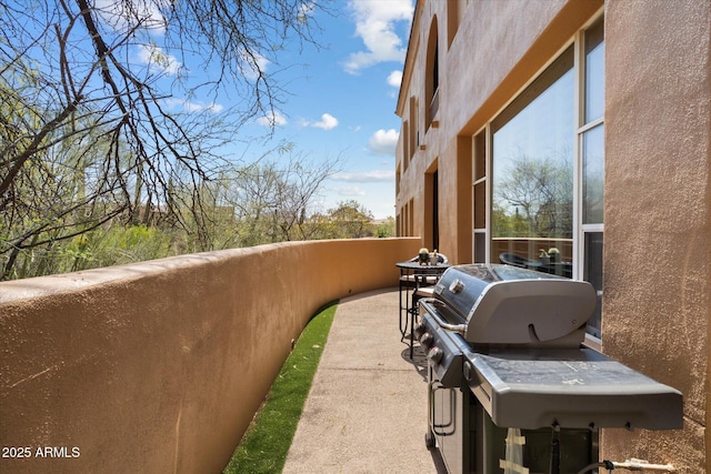 view of patio with area for grilling and a balcony