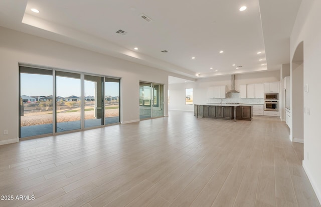 26696 W Siesta Ln, Buckeye, AZ 85396 - unfurnished living room featuring light wood-style flooring, plenty of natural light, recessed lighting, and visible vents