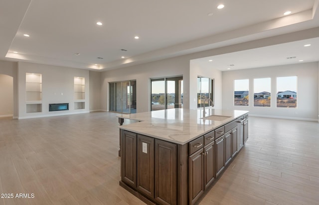 26696 W Siesta Ln, Buckeye, AZ 85396 - kitchen with open floor plan, light wood-type flooring, a sink, and a raised ceiling