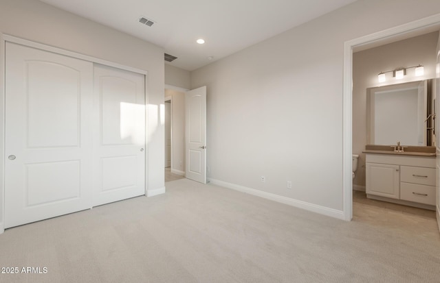 26696 W Siesta Ln, Buckeye, AZ 85396 - unfurnished bedroom featuring a closet, a sink, baseboards, light colored carpet, and visible vents