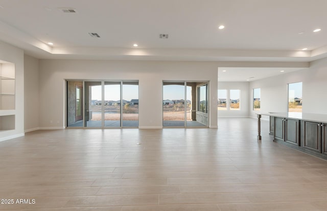 26696 W Siesta Ln, Buckeye, AZ 85396 - unfurnished living room with recessed lighting, light wood finished floors, and a wealth of natural light