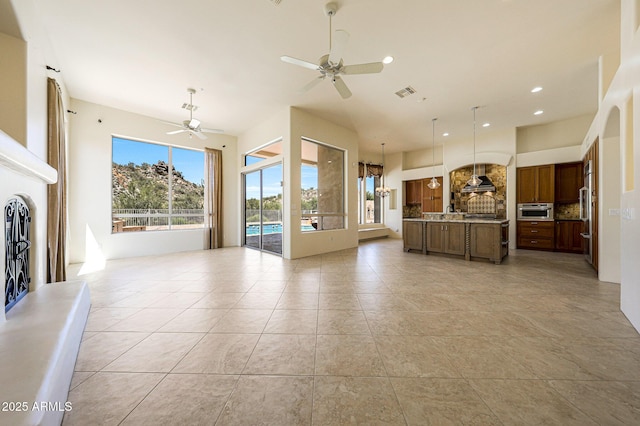 unfurnished living room with light tile patterned floors, ceiling fan, a fireplace with raised hearth, visible vents, and recessed lighting