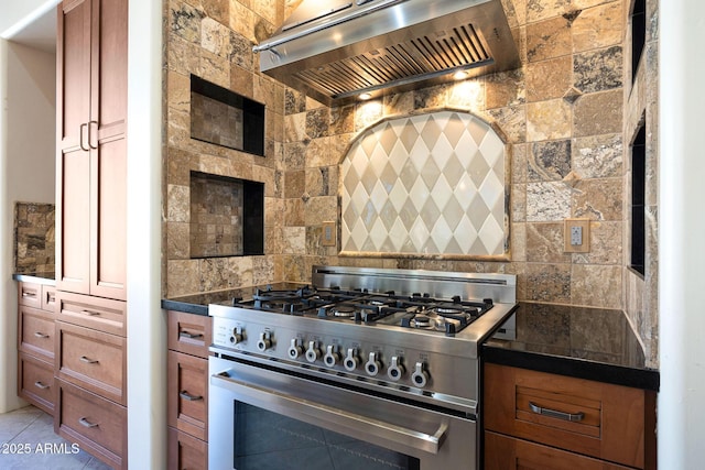 kitchen featuring stainless steel stove, backsplash, exhaust hood, and brown cabinets