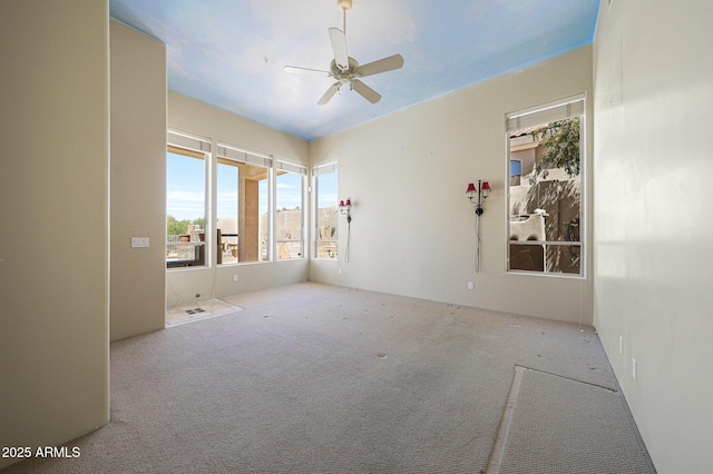 carpeted empty room featuring a ceiling fan