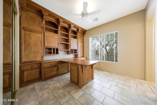 unfurnished office featuring visible vents, a ceiling fan, and built in study area