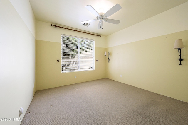 carpeted empty room with visible vents and ceiling fan