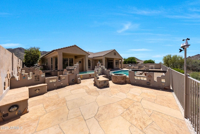 view of patio featuring a jacuzzi, a fenced in pool, area for grilling, an outdoor fire pit, and a fenced backyard