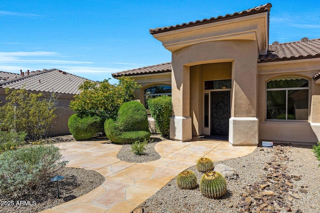 exterior space featuring fence, stucco siding, and a tiled roof