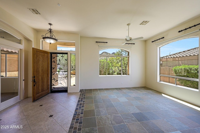 foyer featuring visible vents and ceiling fan