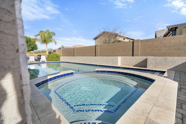 view of pool with a fenced in pool, fence, and an in ground hot tub