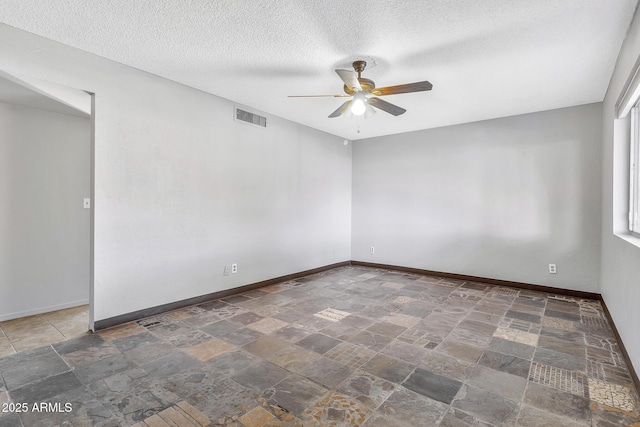 unfurnished room with ceiling fan and a textured ceiling