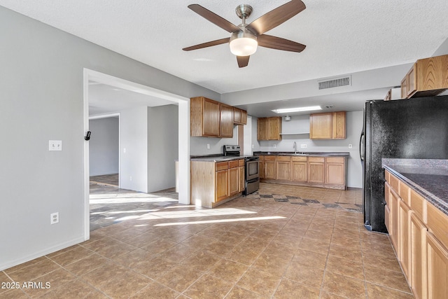 kitchen featuring sink, stainless steel electric range, ceiling fan, a textured ceiling, and black fridge