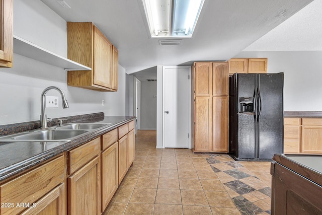 kitchen featuring light tile patterned flooring, range with electric cooktop, sink, and black fridge with ice dispenser