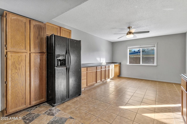 kitchen with light tile patterned floors, black fridge with ice dispenser, a textured ceiling, and ceiling fan