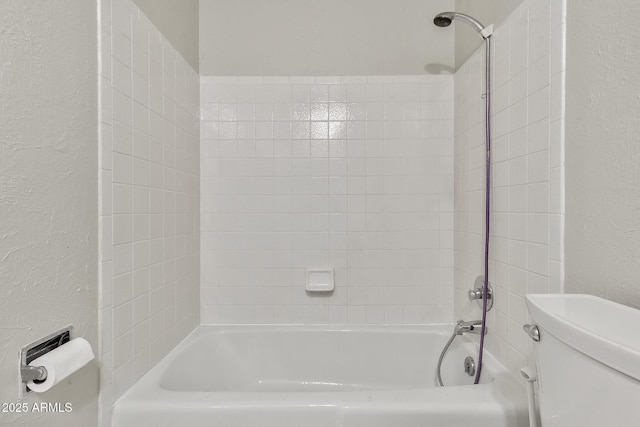 bathroom with tiled shower / bath and toilet