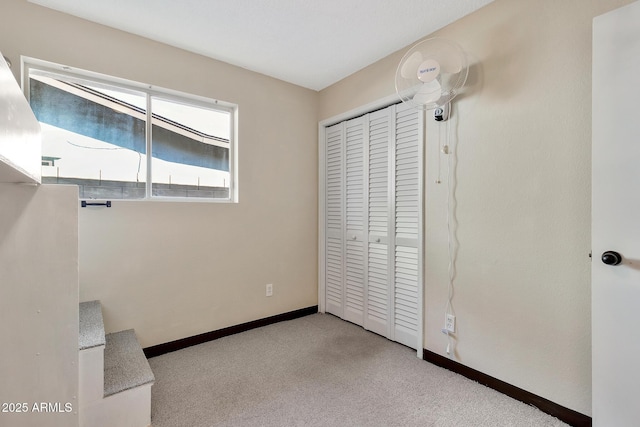 unfurnished bedroom with a closet and light carpet