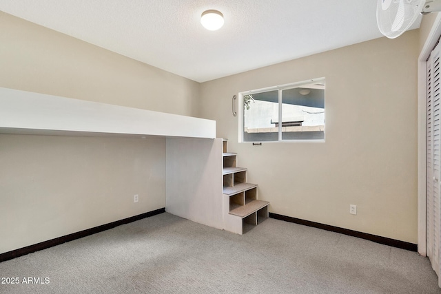 interior space with light colored carpet and a textured ceiling