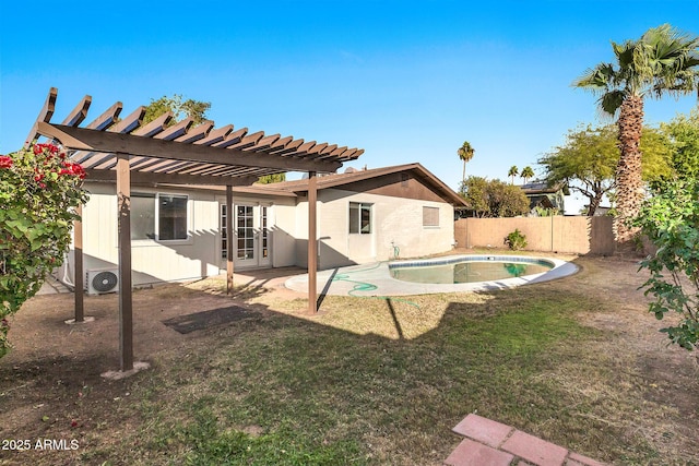 rear view of house with a yard, a pergola, a patio area, and a fenced in pool